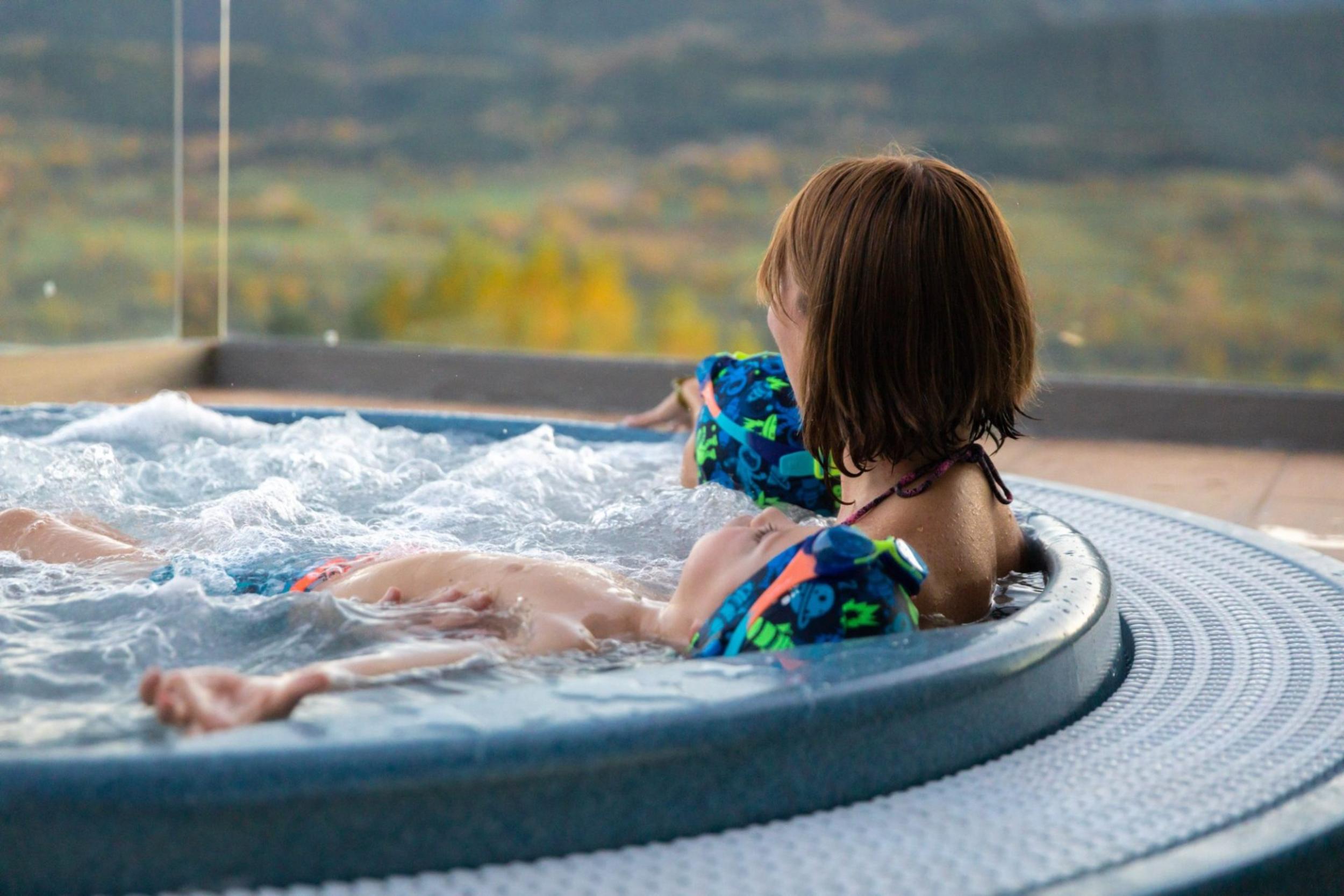 Dona al jacuzzi amb dos nens